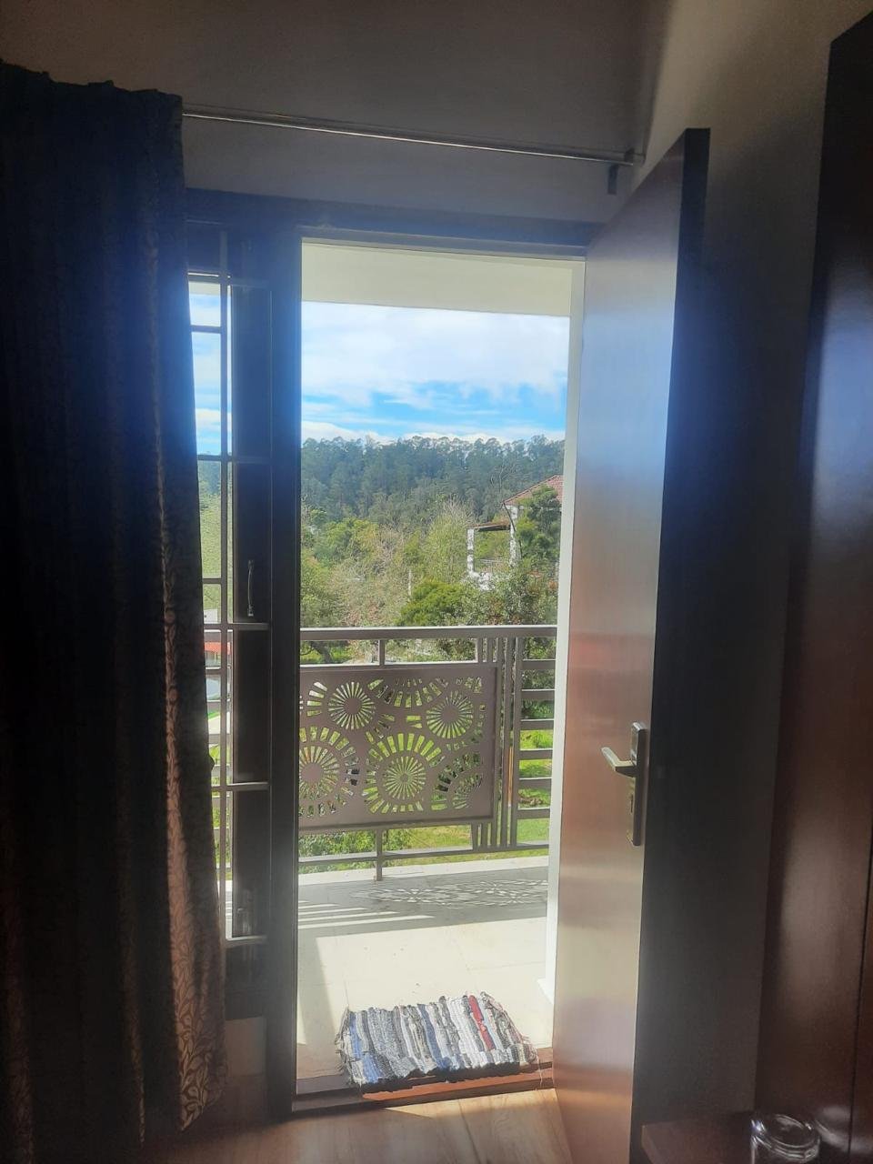Bedroom doorway opening to scenic mountain balcony