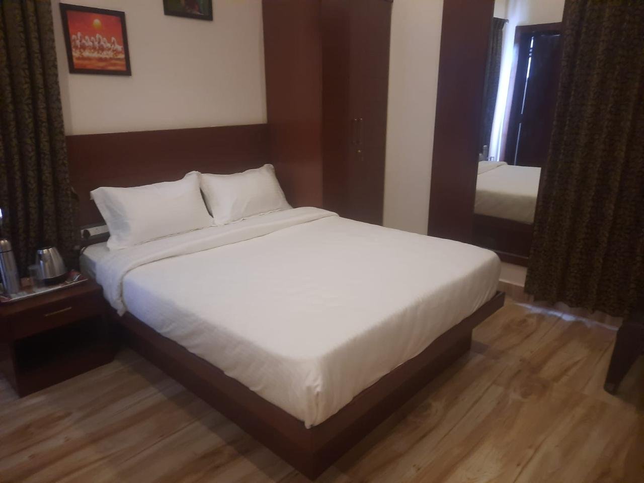 Deluxe room interior with wardrobe, mirror and comfortable chairs