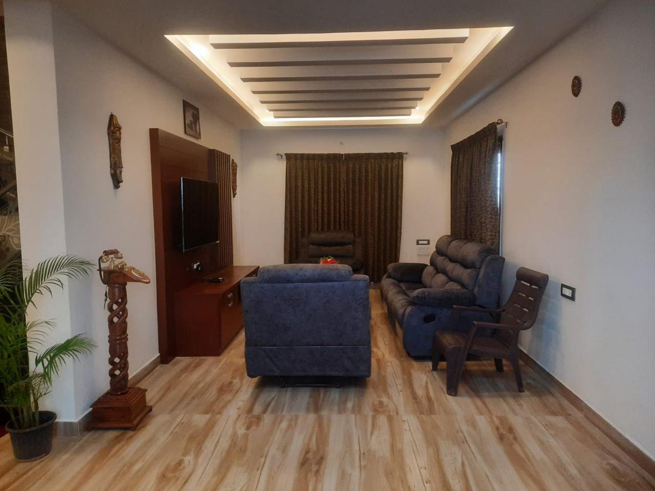 Spacious living hall with plush sofas and large TV
