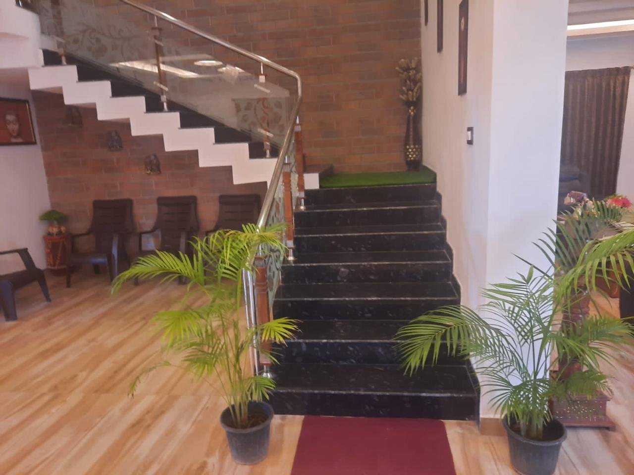 Black granite staircase with indoor potted palm plants